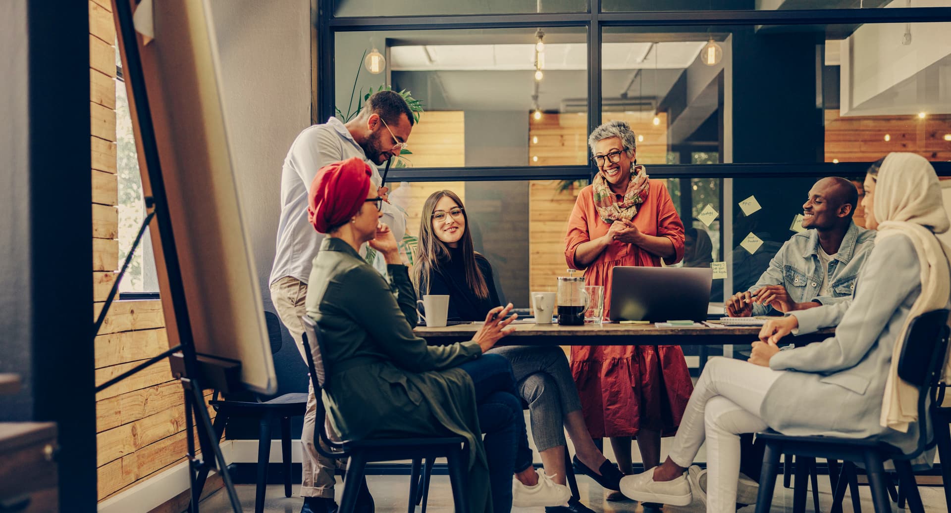 Happy businesspeople smiling cheerfully during a meeting in a creative office. Group of successful business professionals working as a team in a multicultural workplace.